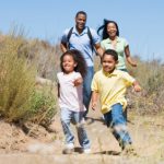 Family running on path smiling